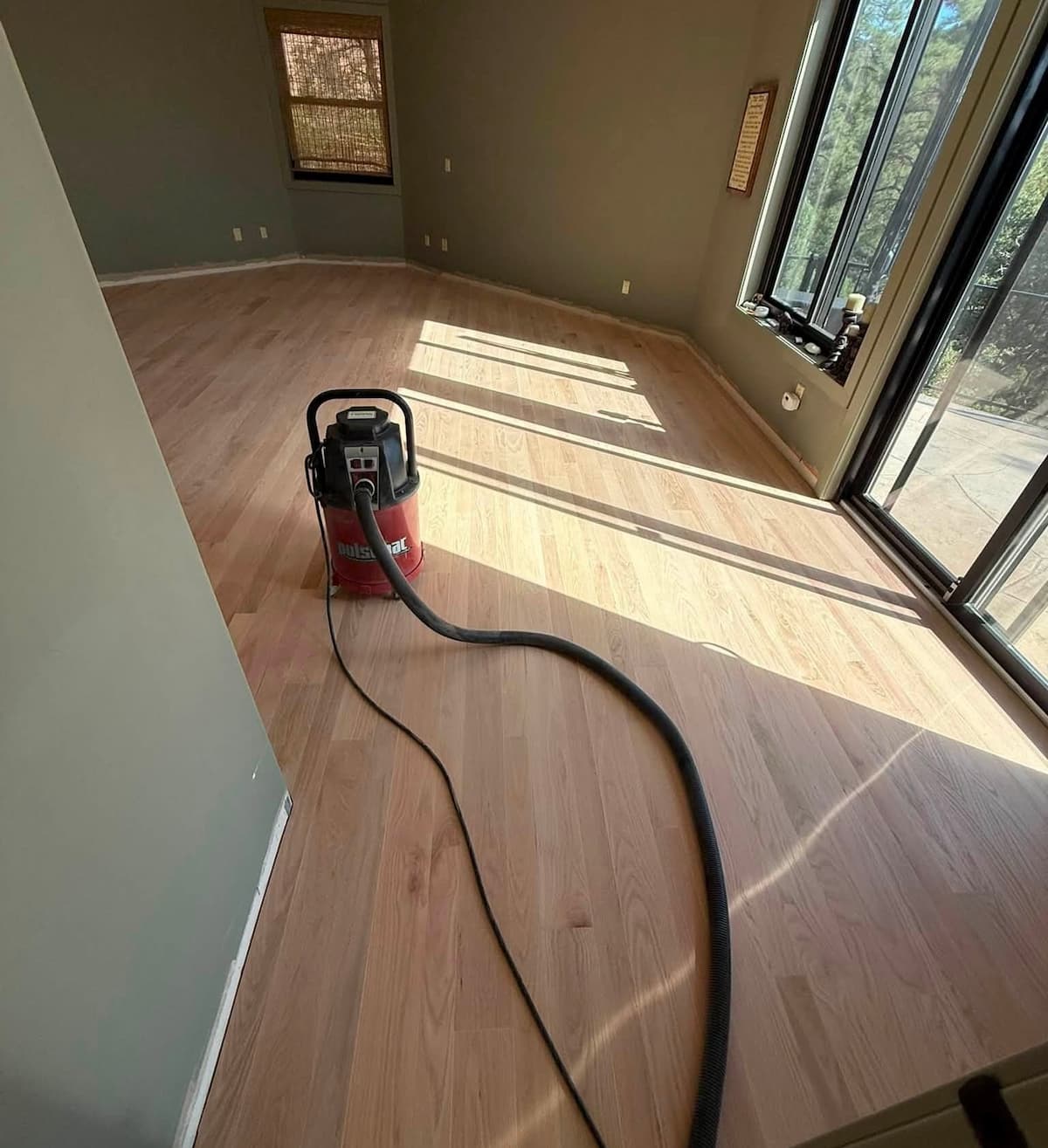 Vacuuming hardwood flooring during refinishing