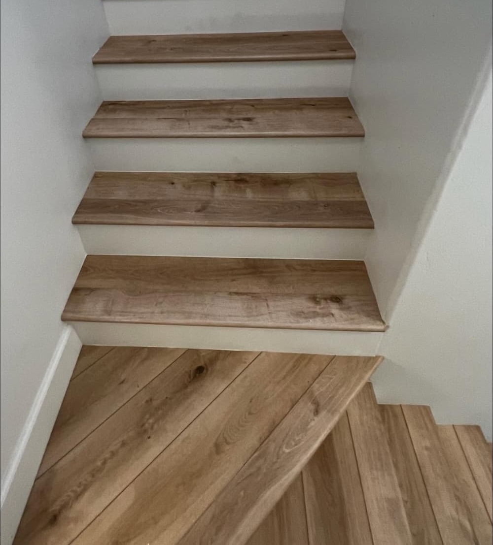 Wood stair treads with white risers and a turning landing